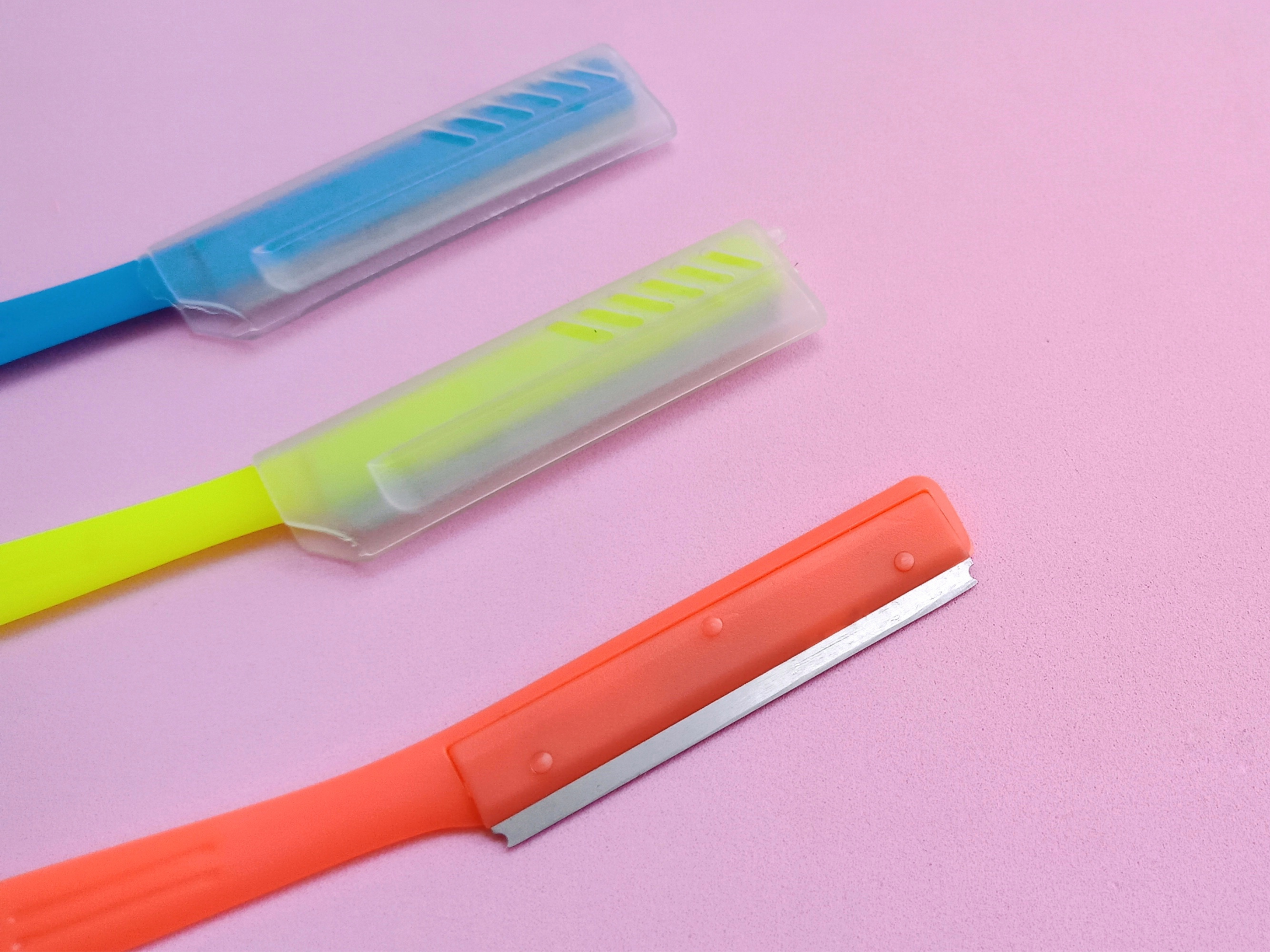 close up of colorful face-shaving razors for women